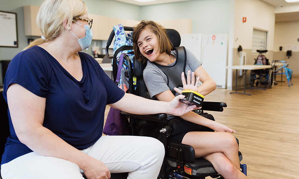 Woman interacts with another woman in a wheel chair at an adult day services location